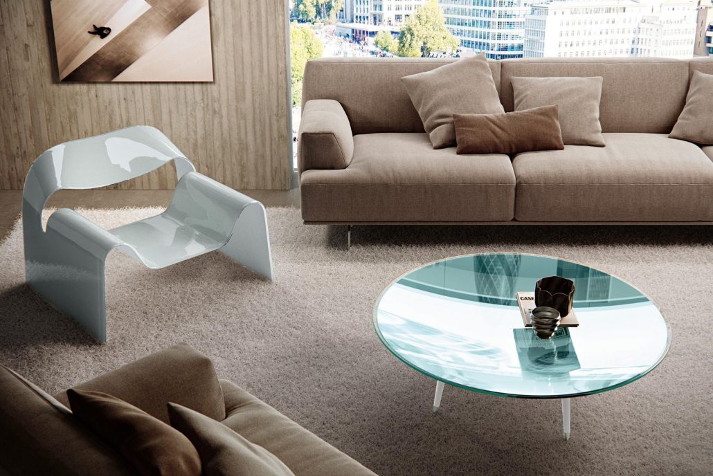 Großzügiger Wohnraum mit beigen Polstermöbeln, skulpturalem Loungechair und Panoramablick auf die Stadt.